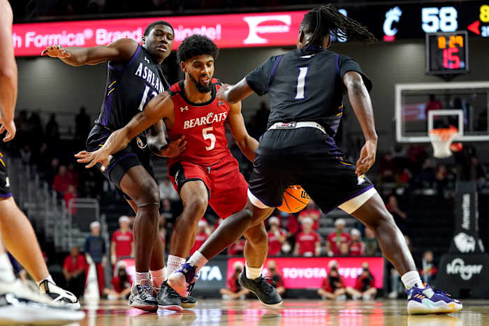 Cincinnati Bearcats guard David DeJulius (5) protects possession as Ashland Eagles guard Dylan Fasoyiro (12) defends in the second half of an NCAA college basketball game, Saturday, Dec. 18, 2021, at Fifth Third Arena in Cincinnati. Ashland Eagles At Cincinnati Bearcats Dec 18